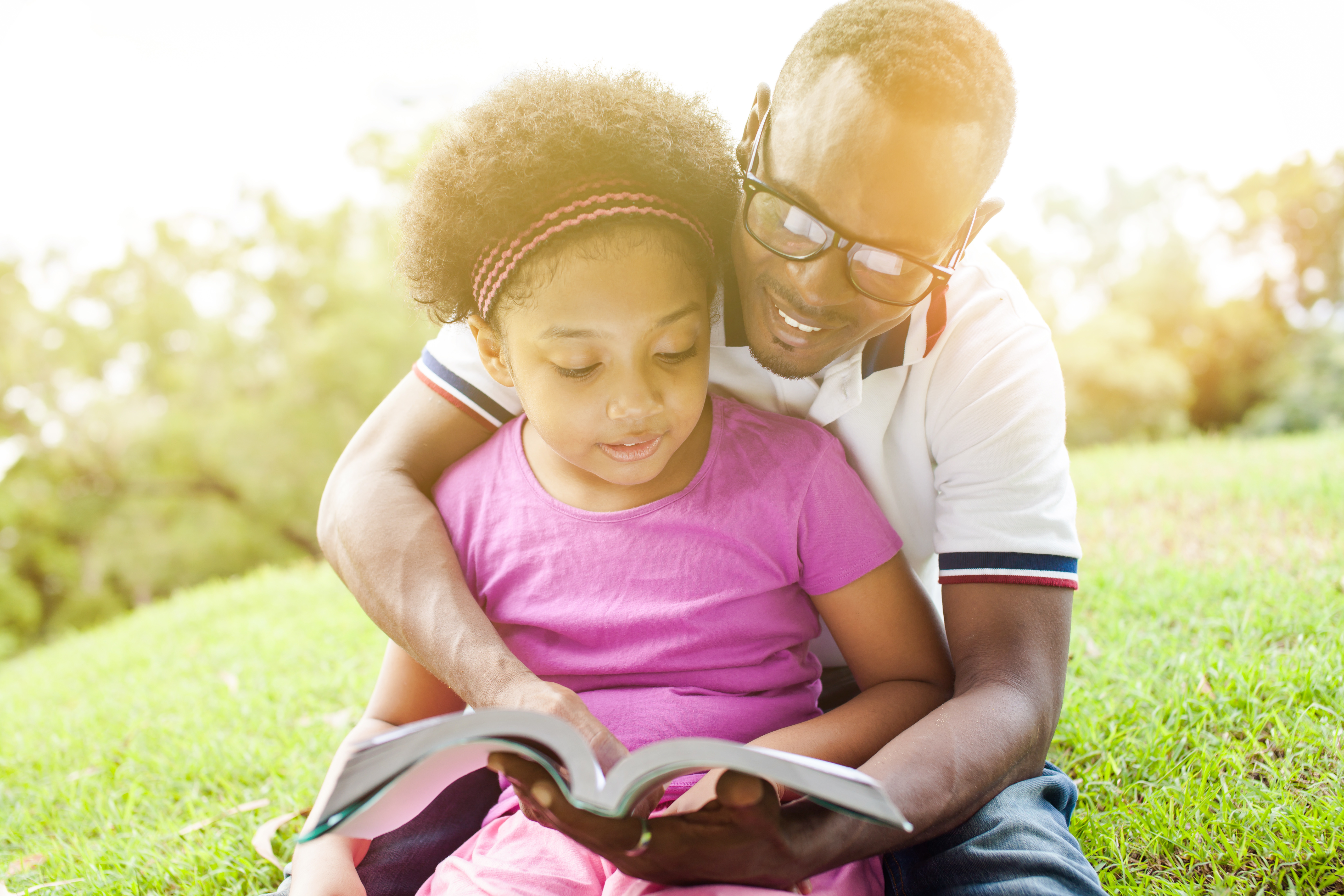 Father and Daughter reading outdoors